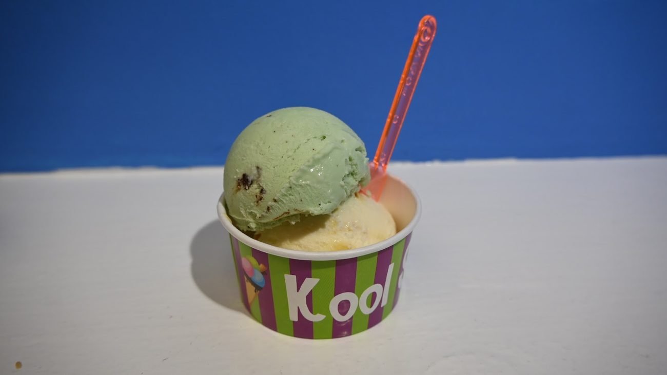 A scoop of ice cream in a Kool Scoops tub against a blue Dingle sky